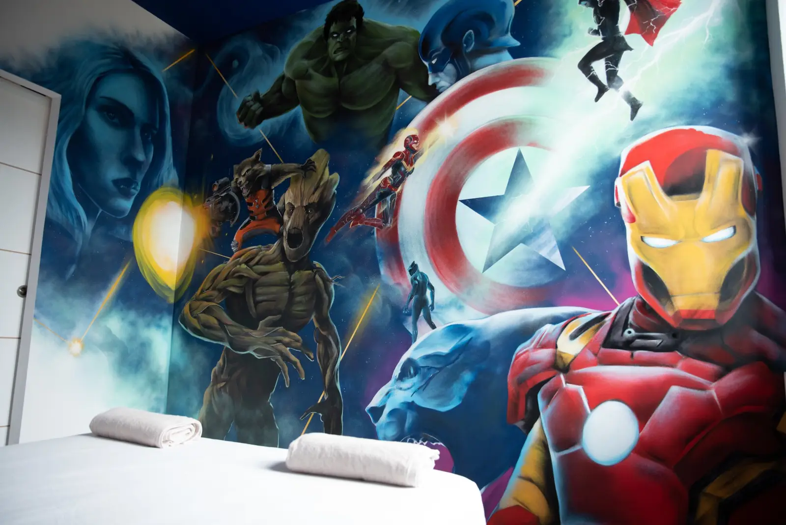 Chambre super-héros : lit double face à une grande fresque murale colorée